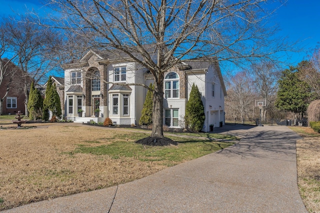 view of front facade with a front lawn and aphalt driveway