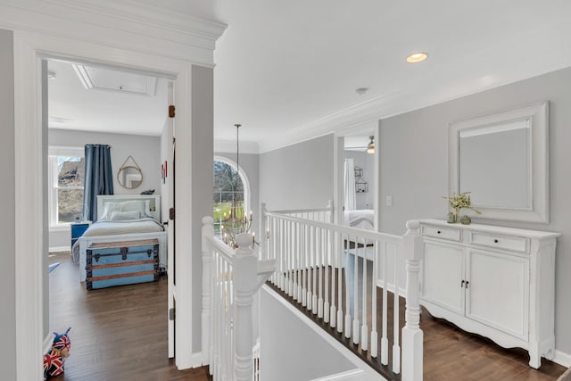 corridor with a chandelier, an upstairs landing, baseboards, dark wood finished floors, and crown molding