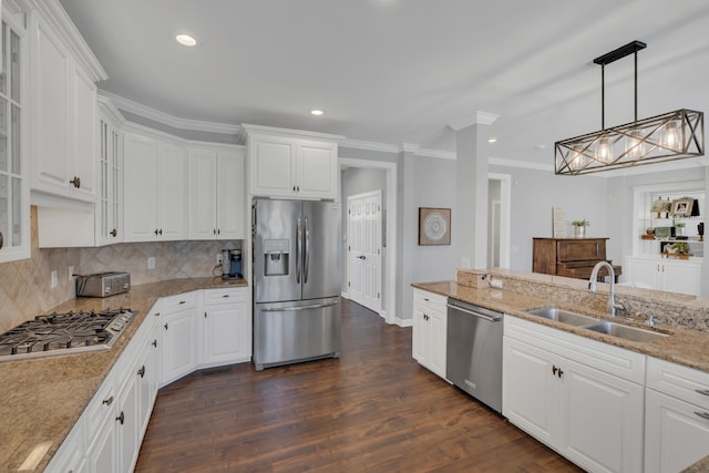 kitchen featuring white cabinets, dark wood finished floors, appliances with stainless steel finishes, crown molding, and a sink