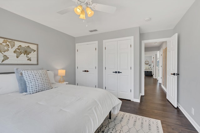 bedroom with a ceiling fan, baseboards, visible vents, and dark wood-type flooring