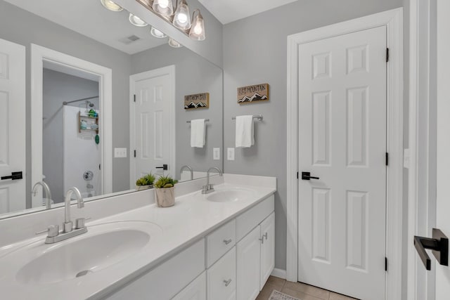 bathroom featuring a shower, tile patterned flooring, a sink, and double vanity