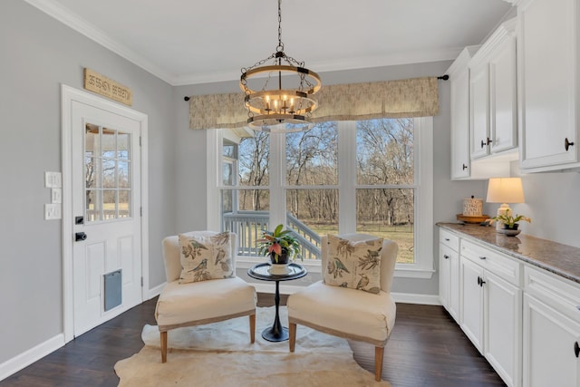 sitting room featuring dark wood-style floors, a chandelier, ornamental molding, and baseboards