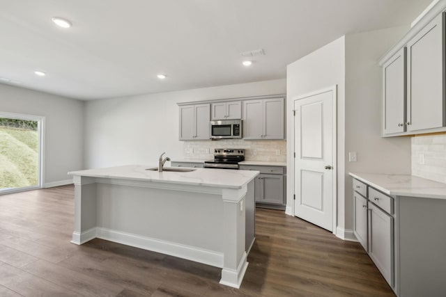 kitchen with dark wood-style floors, stainless steel appliances, a sink, and gray cabinetry