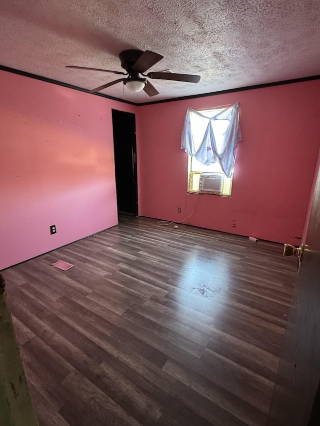 empty room with a ceiling fan, a textured ceiling, cooling unit, and wood finished floors