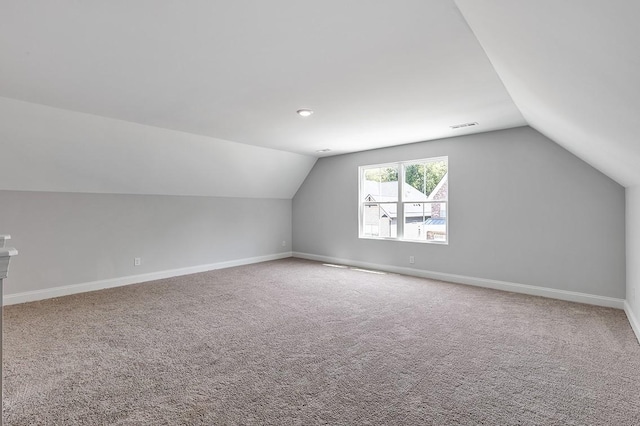 additional living space featuring visible vents, baseboards, and vaulted ceiling