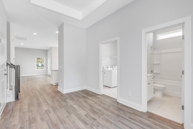 empty room featuring baseboards, washing machine and clothes dryer, visible vents, and light wood-style floors