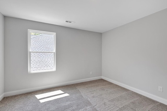 carpeted empty room featuring visible vents and baseboards