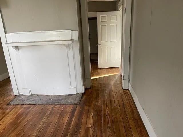 corridor with baseboards and hardwood / wood-style floors