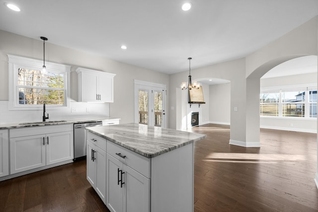 kitchen featuring dishwasher, open floor plan, a sink, and dark wood finished floors