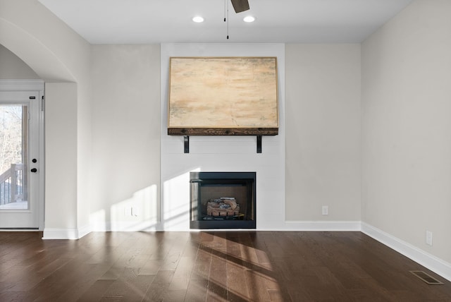 unfurnished living room featuring recessed lighting, a fireplace, baseboards, and wood finished floors