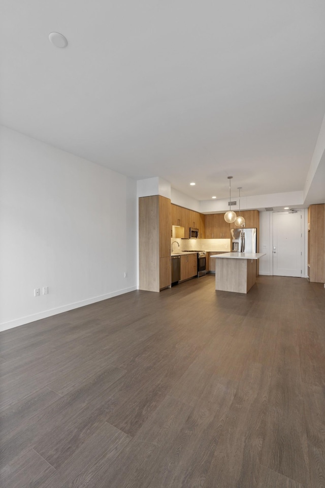 unfurnished living room featuring recessed lighting, dark wood-type flooring, and baseboards