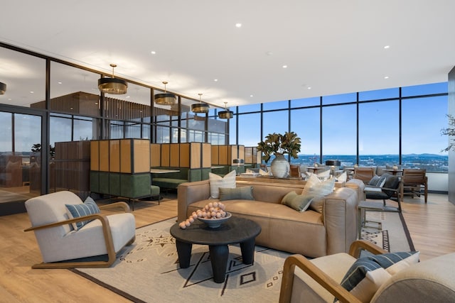 living room with a wall of windows and wood finished floors