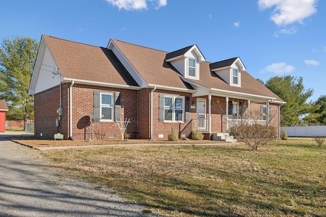 new england style home featuring brick siding, a shingled roof, crawl space, fence, and a front yard