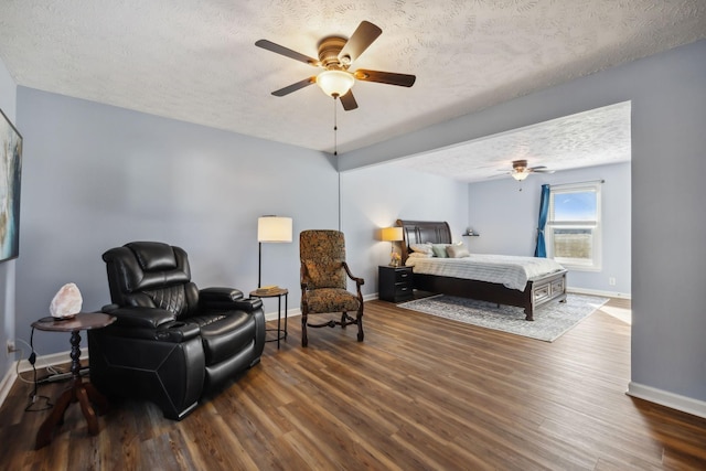 bedroom featuring a textured ceiling, dark wood finished floors, and baseboards