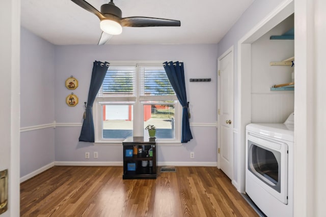 interior space featuring laundry area, wood finished floors, visible vents, and baseboards