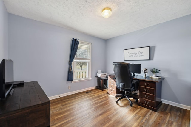 office area featuring a textured ceiling, wood finished floors, and baseboards