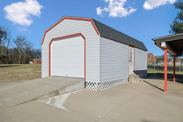 detached garage with concrete driveway and fence