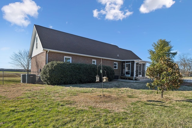 view of front of home featuring a front yard, a sunroom, brick siding, and fence