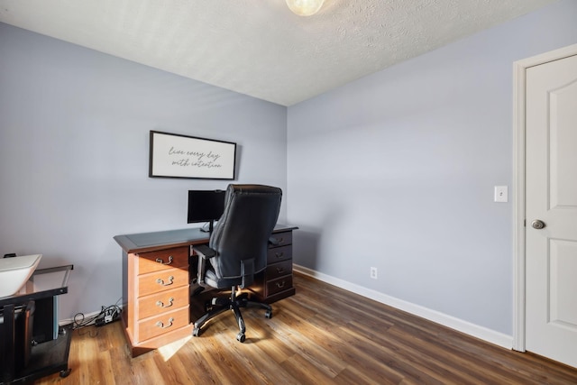 home office featuring a textured ceiling, wood finished floors, and baseboards