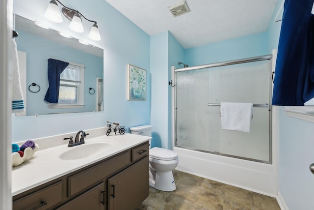 bathroom with visible vents, toilet, combined bath / shower with glass door, a textured ceiling, and vanity