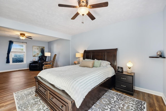 bedroom with a textured ceiling, wood finished floors, and baseboards