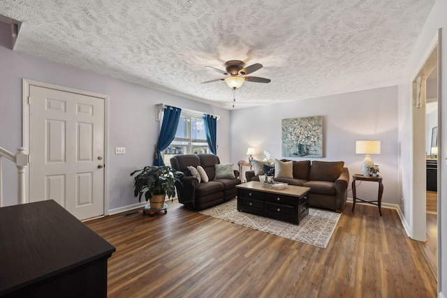 living area featuring baseboards, a textured ceiling, a ceiling fan, and wood finished floors