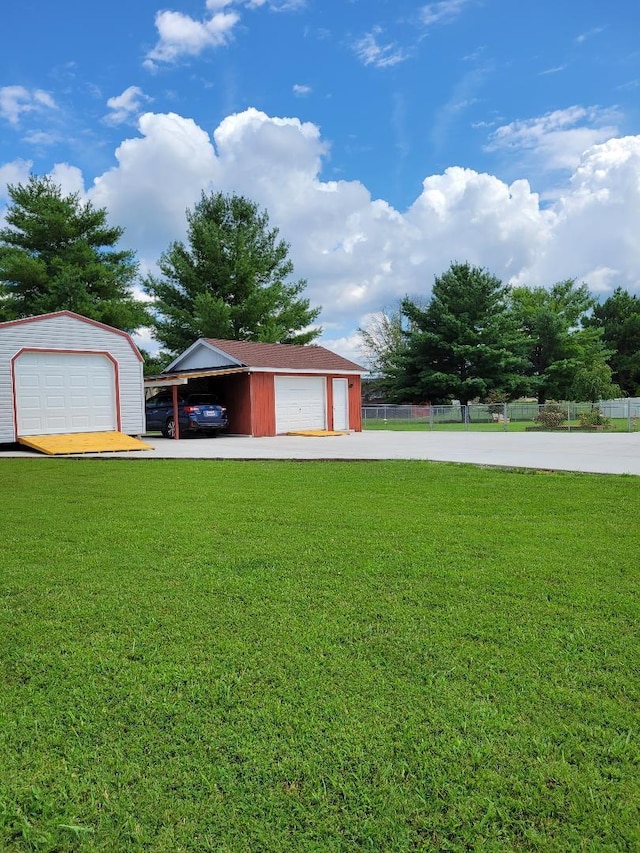 garage featuring a detached garage and fence