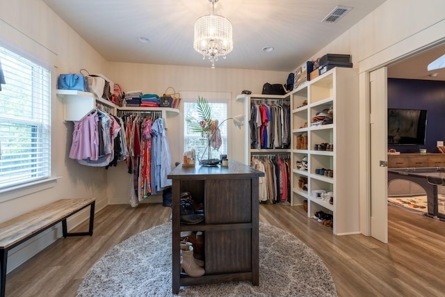 spacious closet with a chandelier, visible vents, and wood finished floors