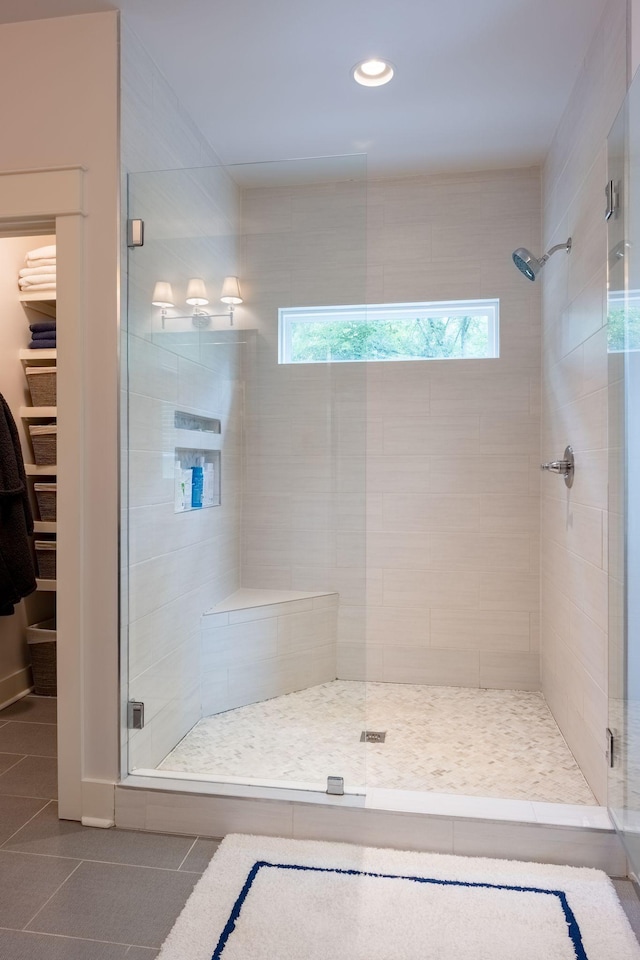 full bath with a spacious closet, a stall shower, recessed lighting, and tile patterned floors