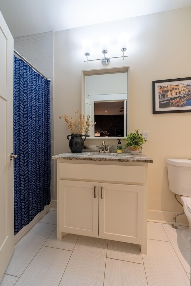 bathroom with curtained shower, tile patterned flooring, vanity, and toilet