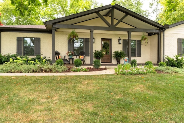 view of front of property featuring covered porch, brick siding, and a front lawn