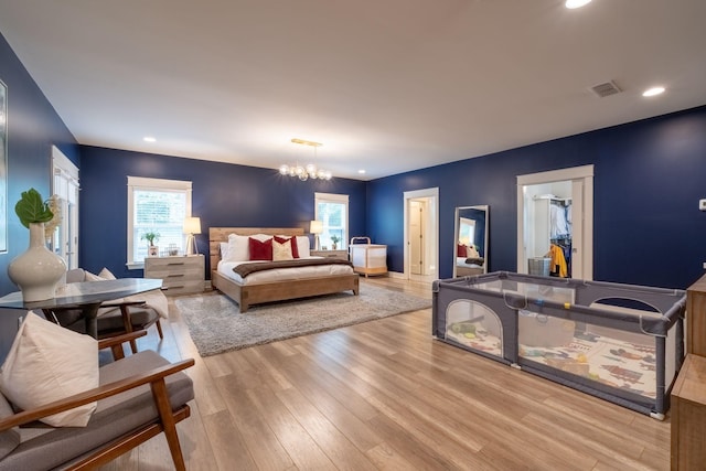 bedroom with recessed lighting, light wood-type flooring, visible vents, and a notable chandelier