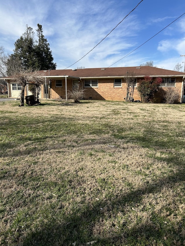 back of house with a yard and brick siding