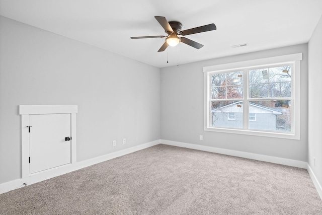 spare room featuring ceiling fan, visible vents, baseboards, and carpet flooring