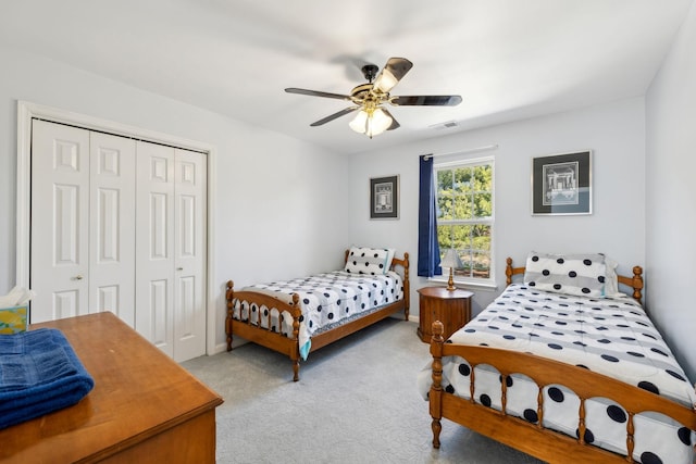 carpeted bedroom featuring a ceiling fan, a closet, and visible vents