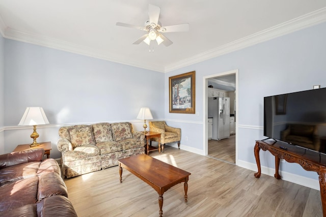 living room featuring baseboards, ceiling fan, ornamental molding, and light wood-style floors