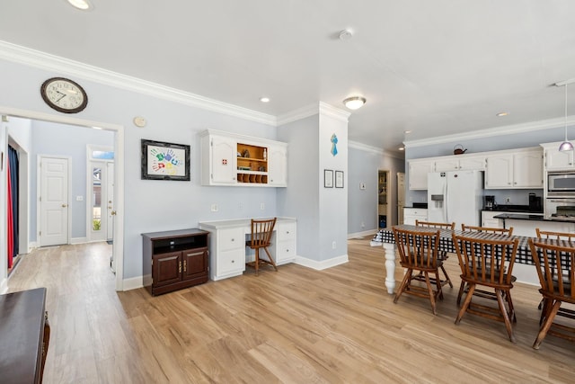 interior space with built in desk, recessed lighting, light wood-style flooring, ornamental molding, and baseboards