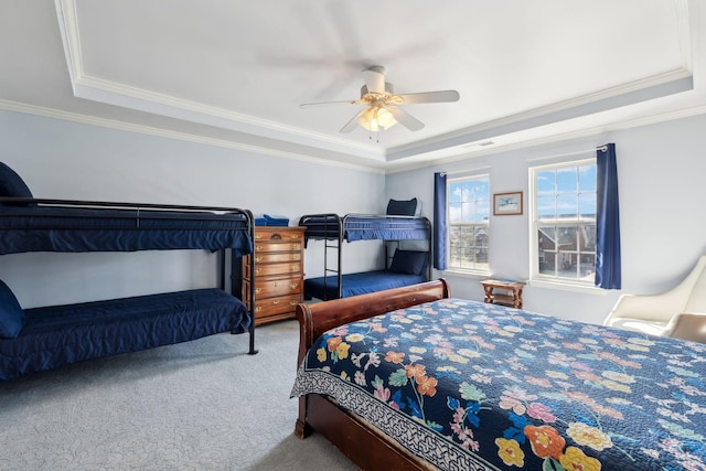 carpeted bedroom with ornamental molding and a raised ceiling