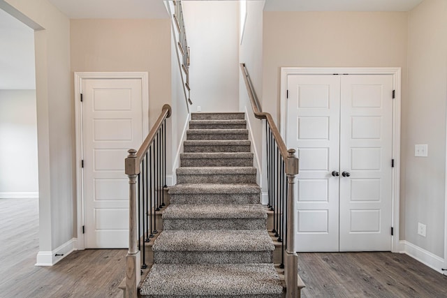 stairs with wood finished floors and baseboards