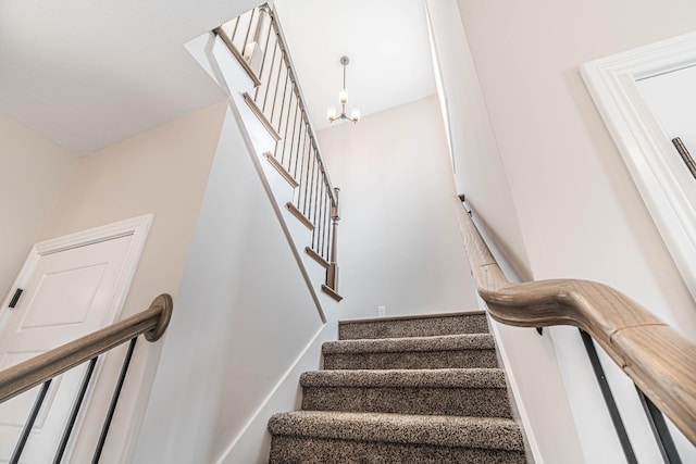 stairs featuring a chandelier