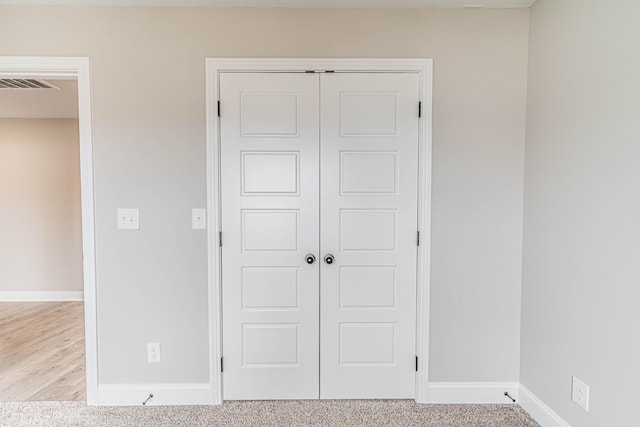 unfurnished bedroom featuring visible vents, baseboards, a closet, and carpet flooring