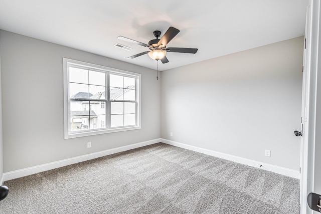 spare room featuring carpet flooring, visible vents, ceiling fan, and baseboards