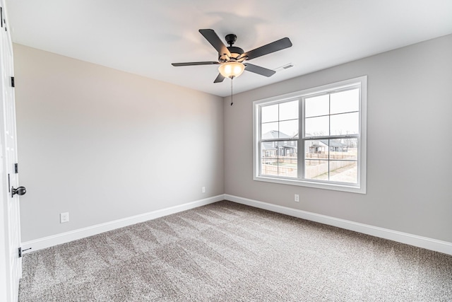 carpeted empty room featuring visible vents, baseboards, and ceiling fan