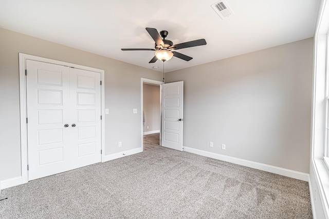 unfurnished bedroom with ceiling fan, carpet flooring, visible vents, baseboards, and a closet