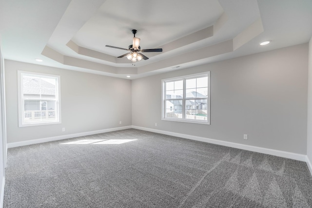 carpeted empty room with baseboards, a raised ceiling, a ceiling fan, and recessed lighting