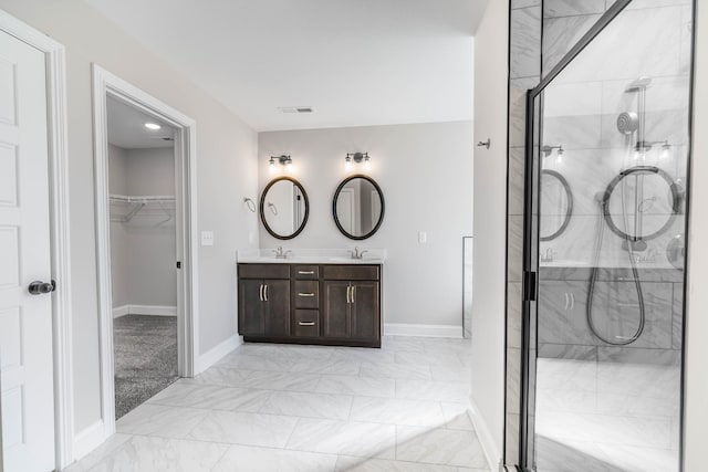 bathroom featuring double vanity, visible vents, marble finish floor, a walk in closet, and a shower stall