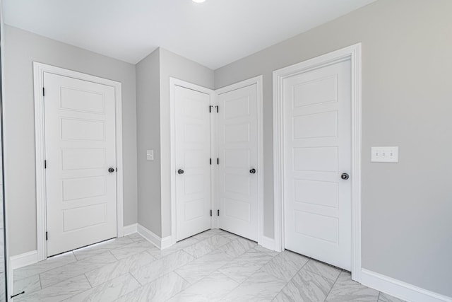 entryway featuring marble finish floor and baseboards