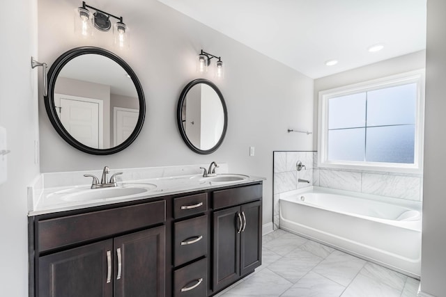 full bathroom with marble finish floor, a garden tub, a sink, and double vanity