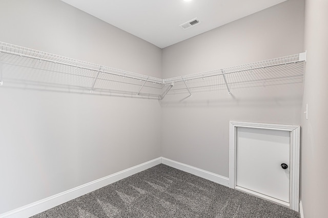 spacious closet with visible vents and dark carpet