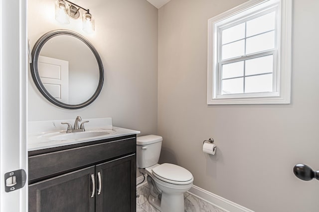 bathroom with marble finish floor, baseboards, vanity, and toilet